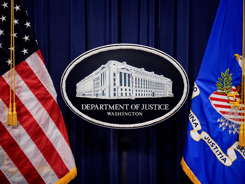 The Department of Justice logo is displayed before U.S. Attorney General Pam Bondi arrives for a news conference at the agency on May 6 in Washington, D.C. The department announced in a June memo that it is aggressively prioritizing efforts to strip some Americans of their U.S. citizenship.