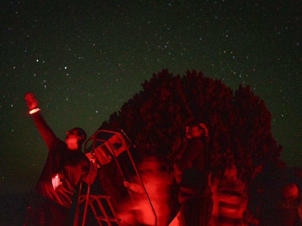 Ethan Day, a telescope operator, points to the sky while helping attendees look through a telescope during a star party at McDonald Observatory in Fort Davis, Texas, on May 27.