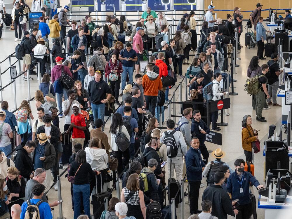 Travelers go through security at San Francisco International Airport the Friday before Memorial Day. AAA predicts Fourth of July weekend will be even busier.