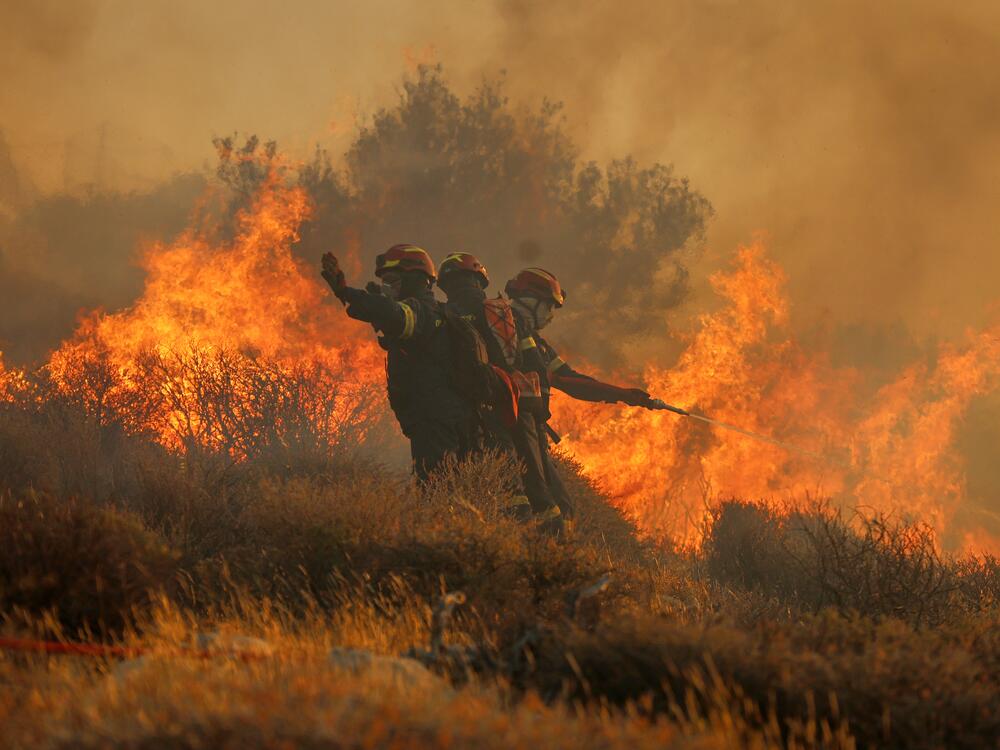 Firefighter uses a hose as the try to extinguish the blaze near the town of Ierapetra on the south coast of Crete island, Greece on Thursday as a fast-moving wildfire prompted authorities to clear villages and coastal areas, officials said.