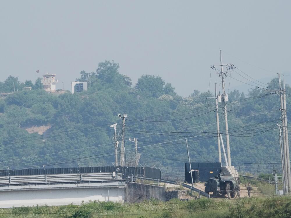 A North Korean military guard post, loudspeaker, top left, and South Korean army soldiers, bottom right, are seen from Paju, South Korea, near the border with North Korea, on June 12.