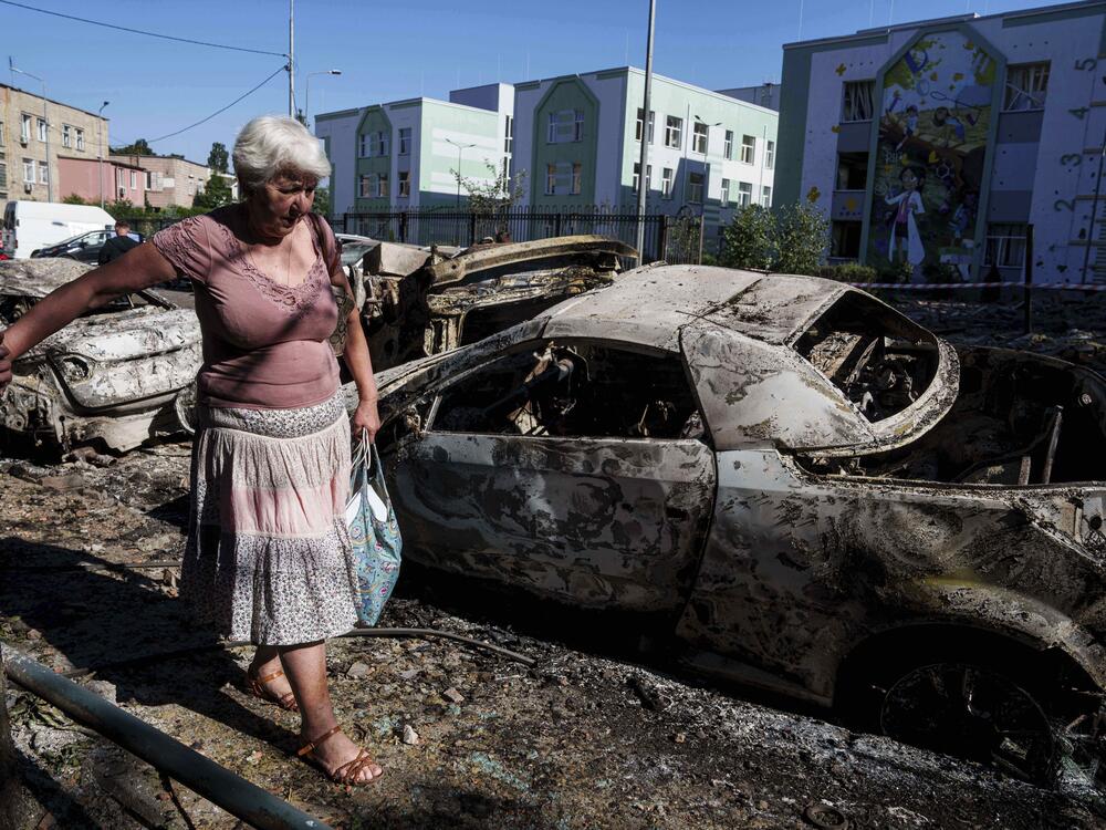 A local woman walks past cars destroyed by a Russian strike in Kyiv, Ukraine.