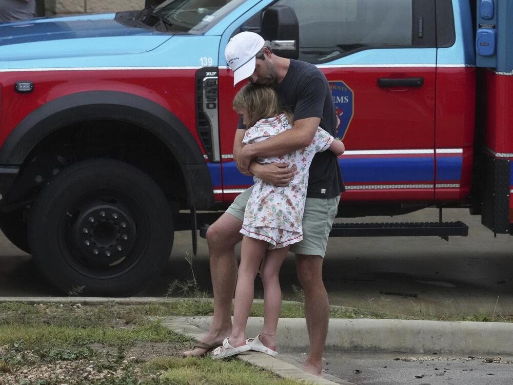 People are reunited Friday at a reunification center in Ingram, Texas, after flash flooding hit the area.