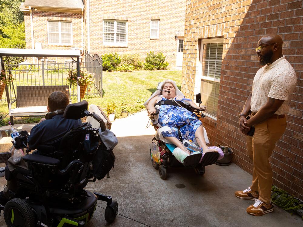 Ratcliff says the patio, with a grill and swing, may be her favorite spot in the new apartment. Bryan Dooley (left) and Adrian Boone, of Solutions for Independence, helped her make the complicated move from the hospital to her new home.