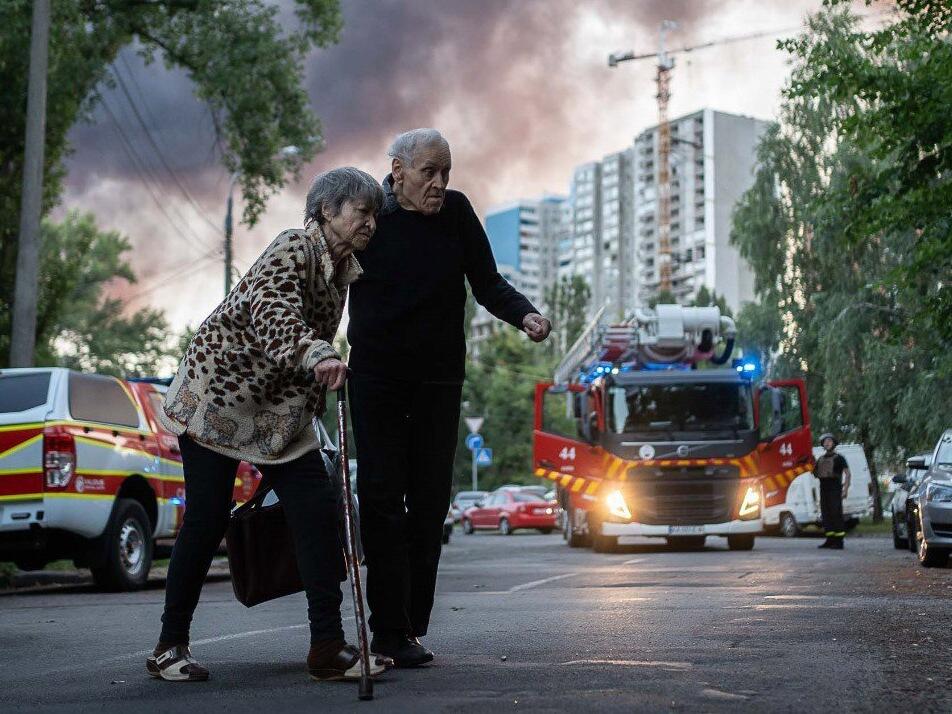 Senior citizens move away from the scene after Russian airstrike in Kyiv, Ukraine.