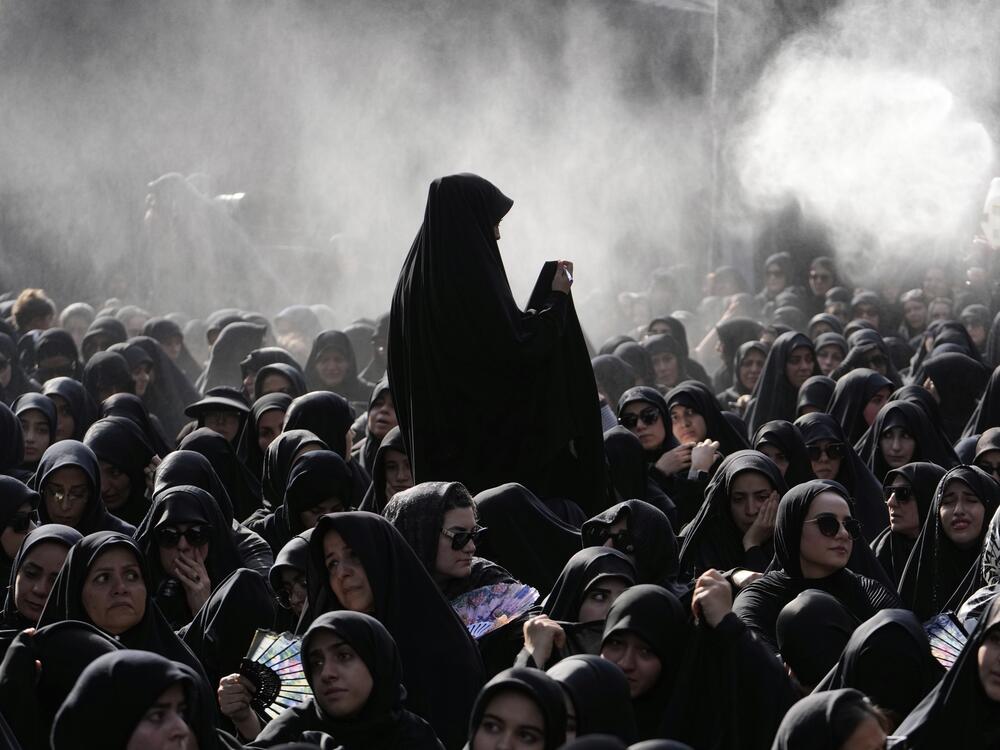 Iranian Shiite Muslims mourn in a ceremony as water is being sprayed for heat management, in Tehran, Iran, Friday, July 4, 2025, ahead of Ashoura, a remembrance of the 7th-century martyrdom of the Prophet Muhammad's grandson.