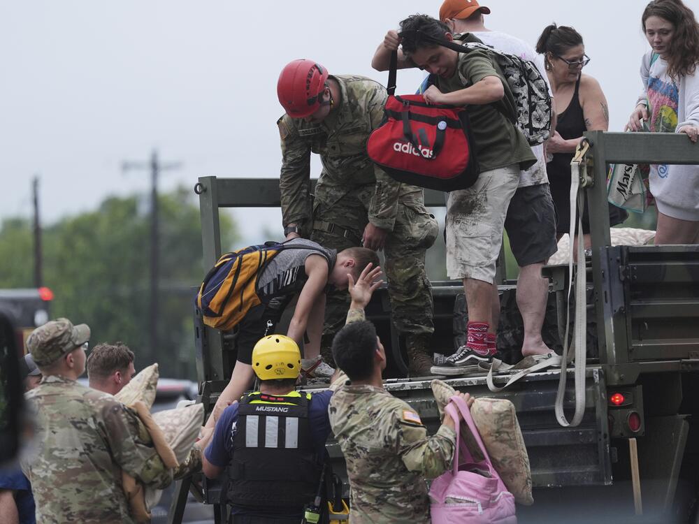 First responders deliver people to a reunification center after flash flooding in the area in Ingram, Texas.