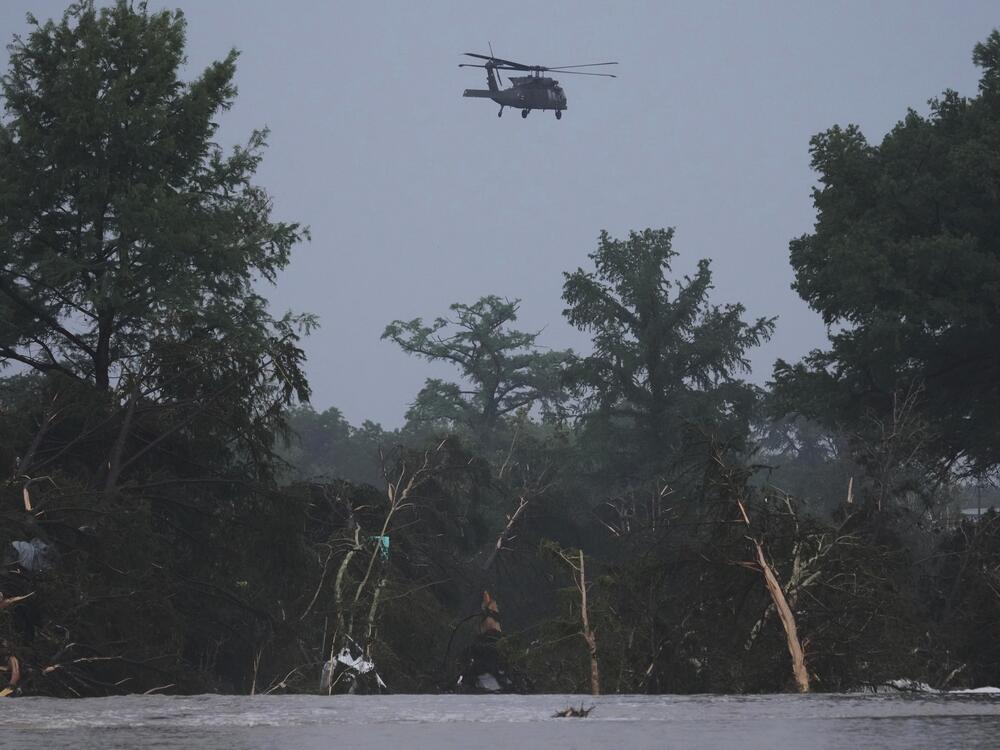 A helicopter flies over the Guadalupe River after a flash flood swept through the area in Kerrville, Texas.