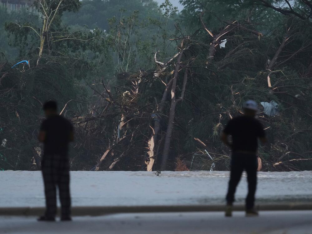 Onlookers survey damage caused along the Guadalupe River after a flash flood swept through the area in Kerrville, Texas.