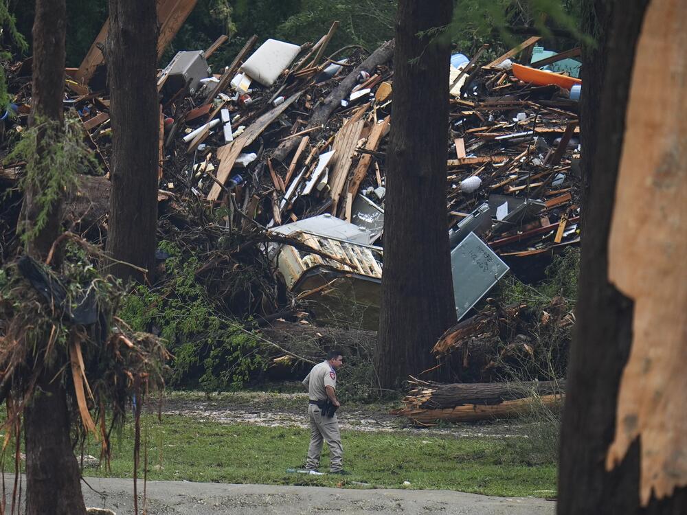 Officials comb through the banks of the Guadalupe River after a flash flood swept through the area in Hunt, Texas.
