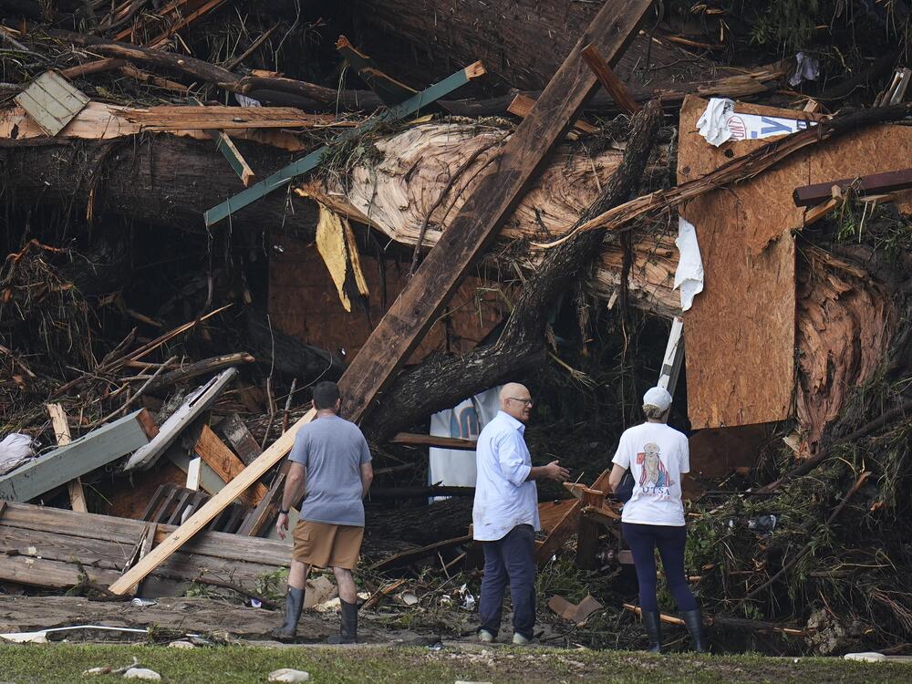 People look at debris on the banks of the Guadalupe River after a flash flood swept through the areain Hunt, Texas.