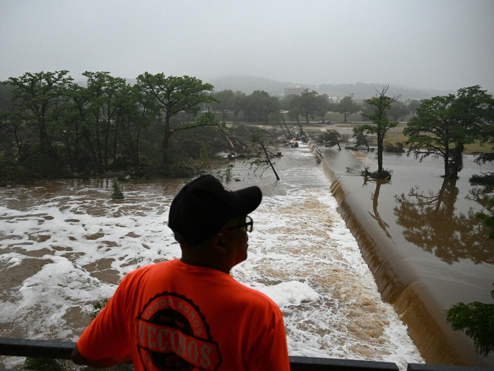 A man looks out at flooding caused by a flash flood at the Guadalupe River in Kerrville, Texas, on Saturday.