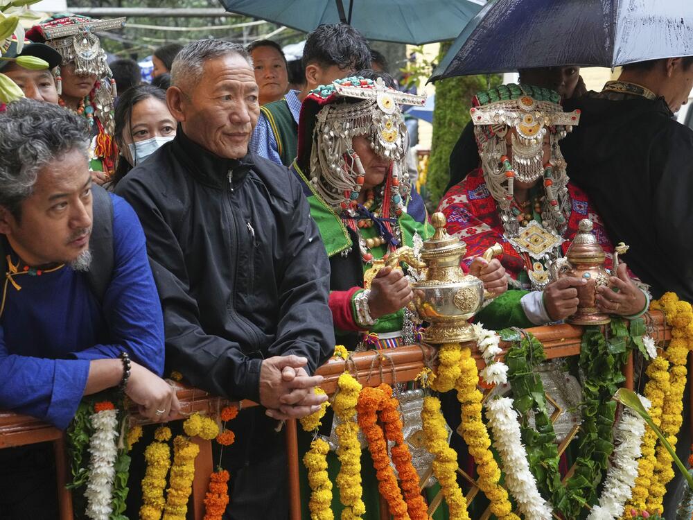 Devotees in their traditional dress wait for the arrival of Tibetan spiritual leader the Dalai Lama to attend an event celebrating his 90th birthday in Dharamshala, India, Sunday.