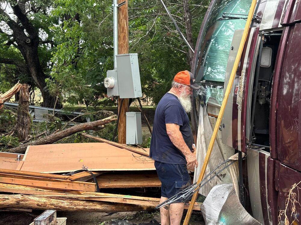 Melvin Harris, 65, cleans up around his motor home, which was flipped by the violent waters of the Guadalupe River in Kerrville, Texas.