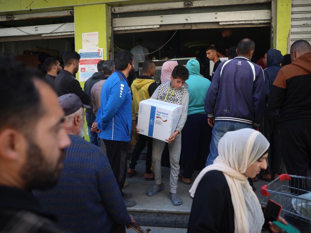 People queue to receive humanitarian aid, supplied by the World Food Program, in the Bureij refugee camp in the central Gaza Strip on Nov. 18, 2024.