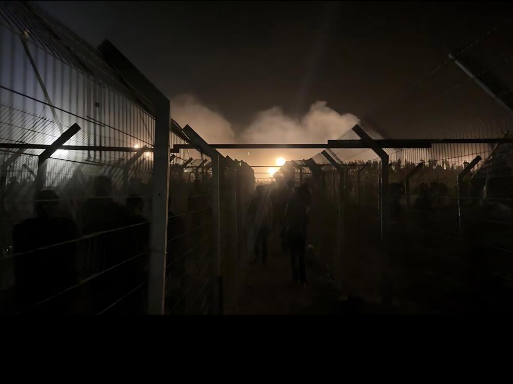 The fenced entrance to a Gaza Humanitarian Foundation food distribution site in central Gaza, open in the middle of the night on June 24, 2025.