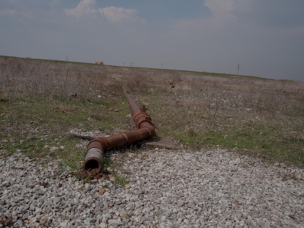 A pipe, left over from a now-defunct piece of oil equipment, stretches across the land in the Tallgrass Prairie Preserve in Oklahoma on March 20, 2024.