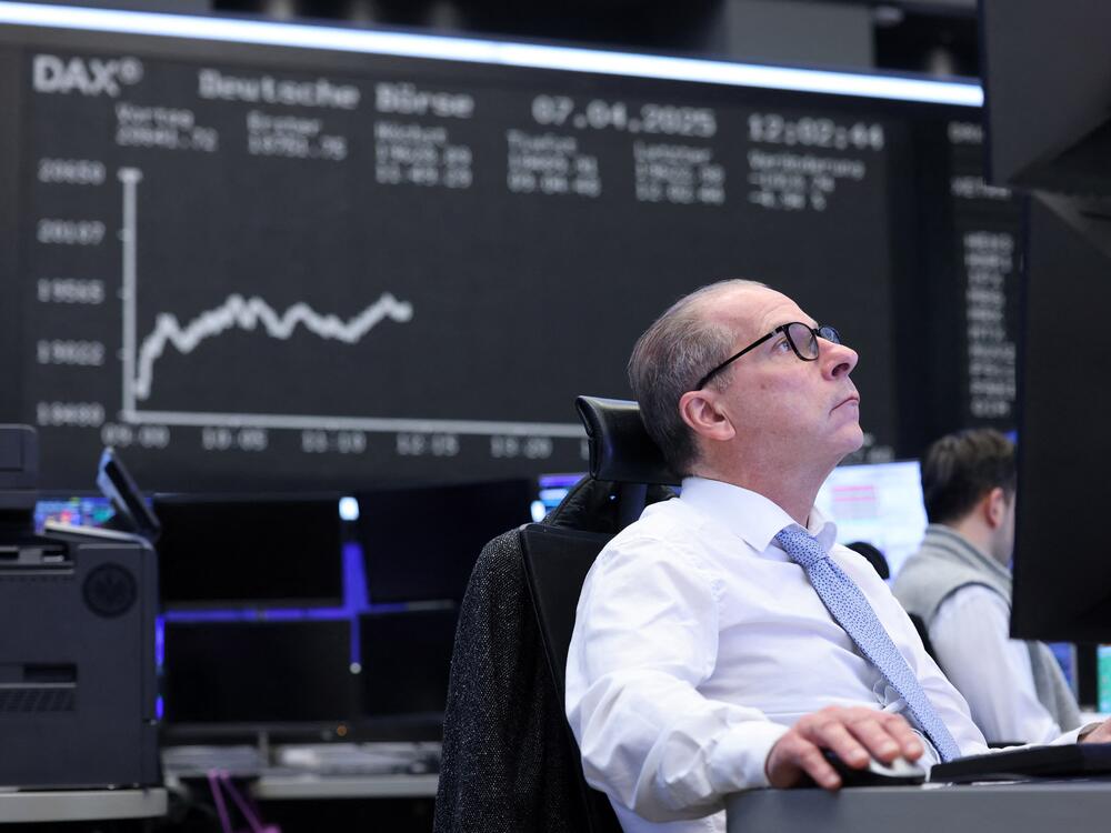 A trader works in front of a board displaying the chart of Germany's DAX index at the stock exchange in Frankfurt, Germany, on April 7, 2025. German stocks have surged this year, outpacing gains in the U.S.