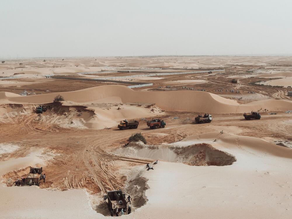 This aerial view show trucks loading sand from a quarry on the outskirts of Nouakchott, Mauritania, on March 14, 2023.