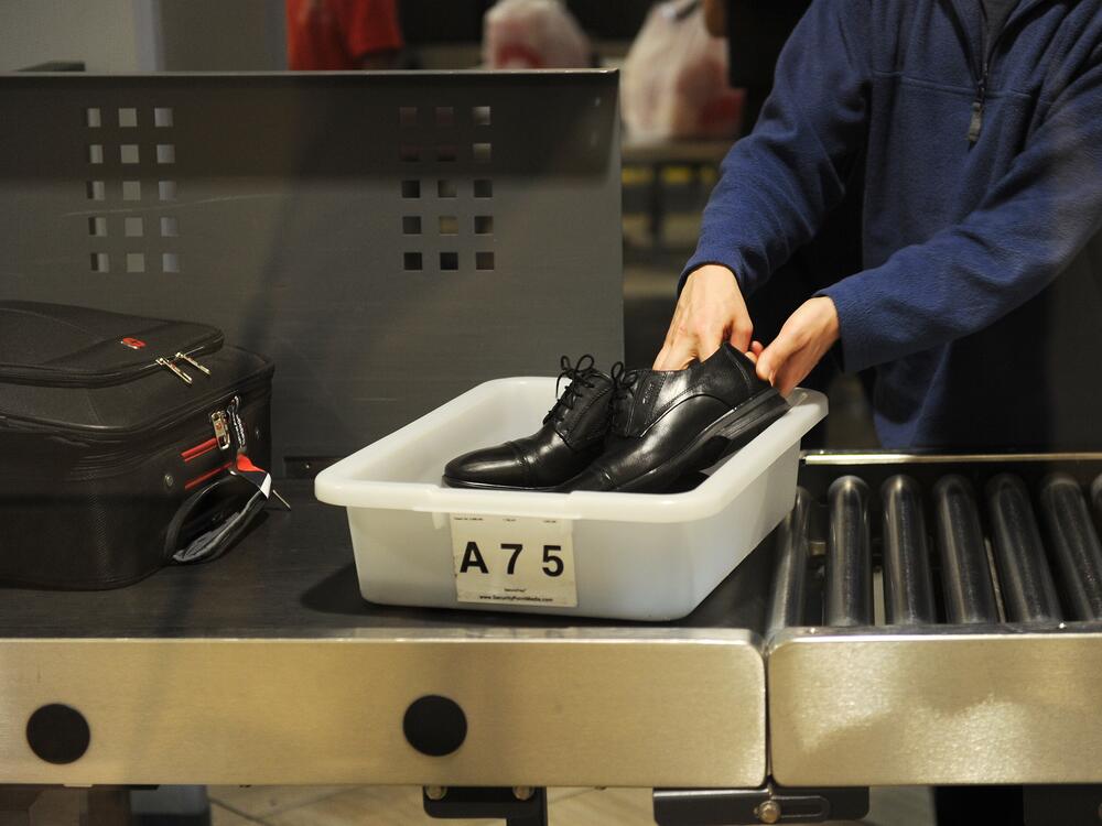 An air traveler puts his shoes in a bin before passing through a Transportation Security Administration (TSA) security checkpoint at Los Angeles International Airport in 2014.