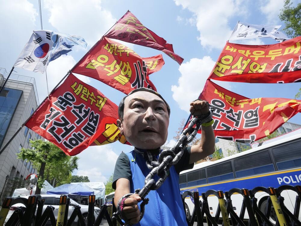 A protester wears a mask of former South Korean President Yoon Suk Yeol during a rally in support of a hearing to review a special prosecutor's request for his arrest, near the Seoul Central District Court in Seoul, South Korea, on Wednesday, July 9, 2025. The writing reads 