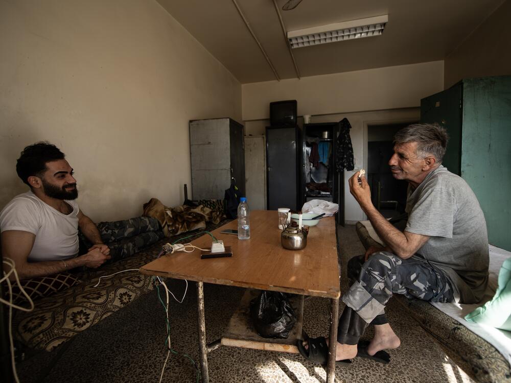Firefighters Mohammed Khdeir and Mahdi Sliman have tea at their side of the firehouse.