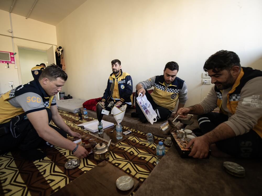 White Helmet members (from left to right) Qassem Masarawi, Ibrahim al-Rihani, Tarek Taleb and Mustafa Bakkar pour coffee for an Eid celebration inside the Kafr Sousa firehouse.