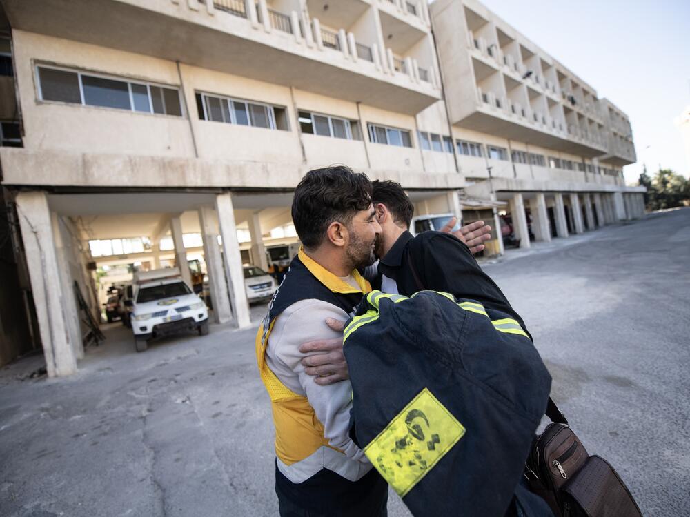 Mustafa Bakkar (left), operations chief for the White Helmets, hugs firefighter Mohammed Khdeir.