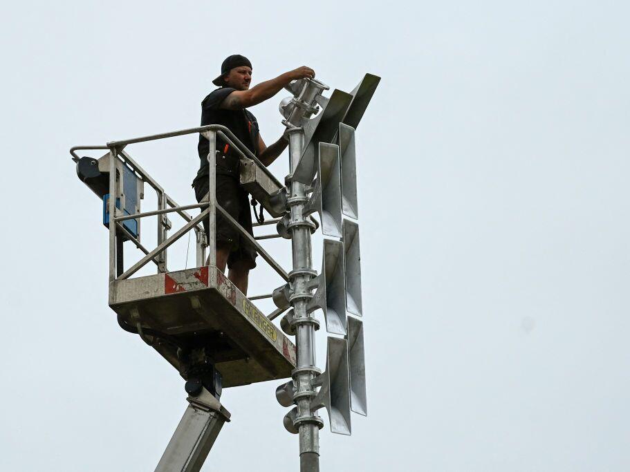 A worker installs flood warning sirens in western Germany in 2022, almost one year after the region was devastated by floods.