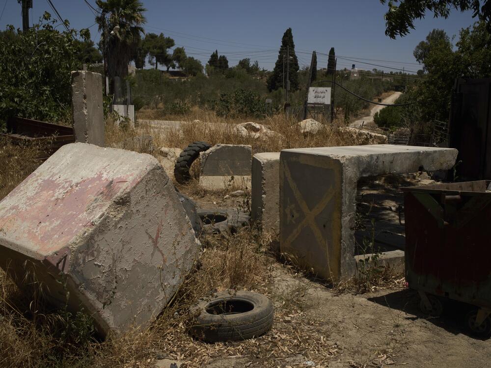 Concrete blocks placed by Israeli soldiers after October 7, 2023, according to local residents, are seen at one of the entrances to the West Bank village of Sinjil, impeding access for Palestinians, on July 9, 2025.