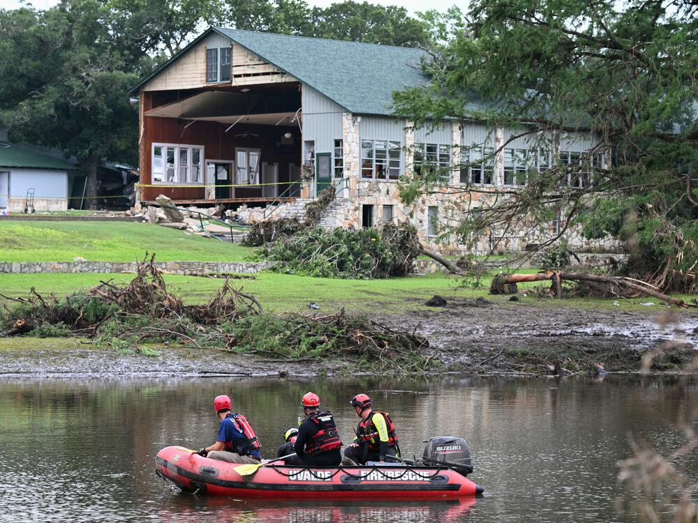 A search and rescue team looks for people along the Guadalupe River near a damaged building at Camp Mystic. Federal regulators repeatedly granted appeals to remove Camp Mystic's buildings from government flood maps that showed they were in an area at high risk of dangerous flooding.