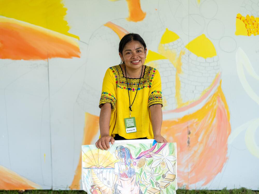 Morán Cojoc poses in front of the rough outlines of her Maya-themed mural.