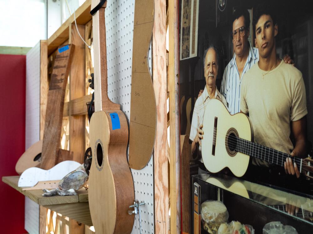 In the photo, Manuel Delgado is pictured (at right) with his father and grandfather — three generations of guitar makers who've been making the instruments since 1928.
