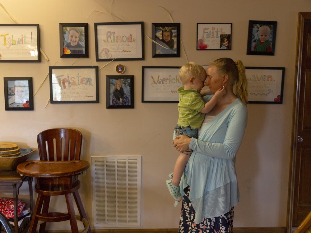 The Algers' youngest child, Sven, cuddles his mother at their home on June 28.