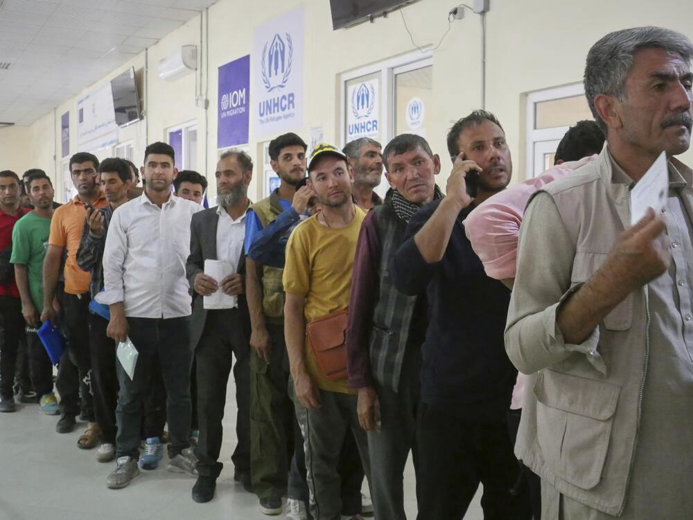 Afghan refugees who returned after fleeing Iran to escape deportation and conflict line up at a UNHCR facility near the Islam Qala crossing in western Herat province, Afghanistan, on Friday, June 20, 2025.