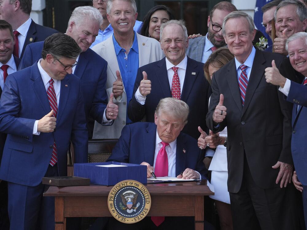 President Trump signs his signature bill of tax breaks and spending cuts at the White House on July 4.