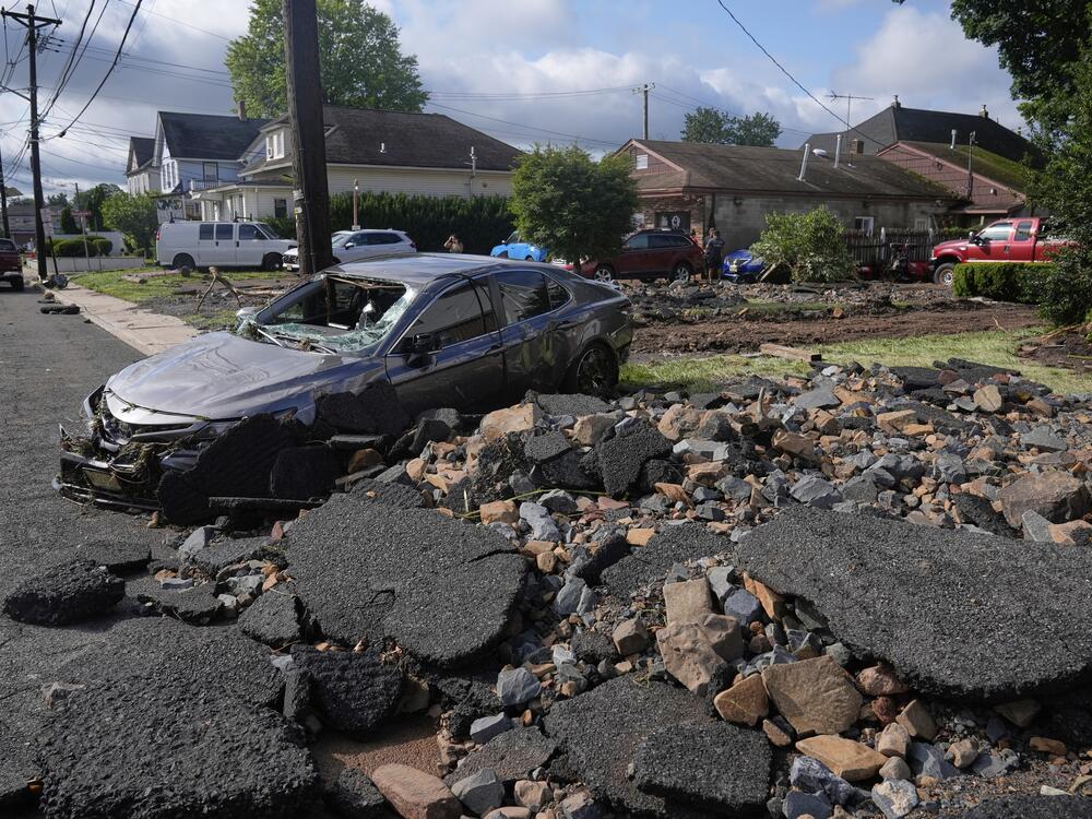 Debris, rubble and a damaged car in North Plainfield, N.J. on Tuesday, July 15, 2025 after flooding from heavy rains in the area. Climate change is causing heavier rain across the United States.