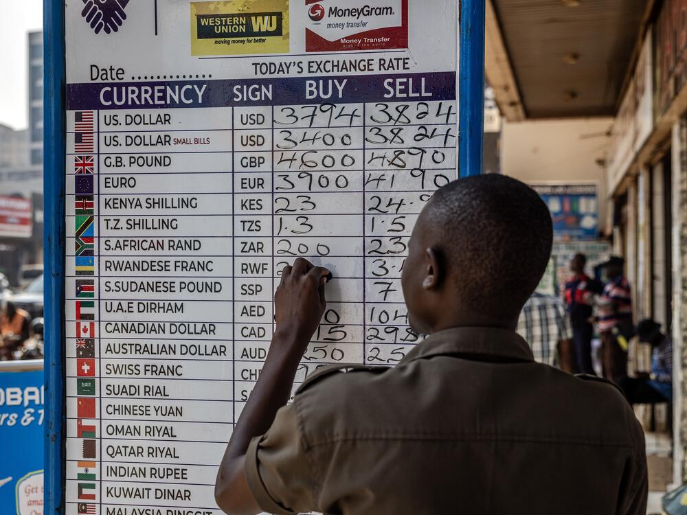 Stablecoins could make international transactions easier in emerging markets where dollars are not that easily accessible. In the picture, a man in Kampala, Uganda, reflects exchange rate changes on a board on Jan. 20, 2024.