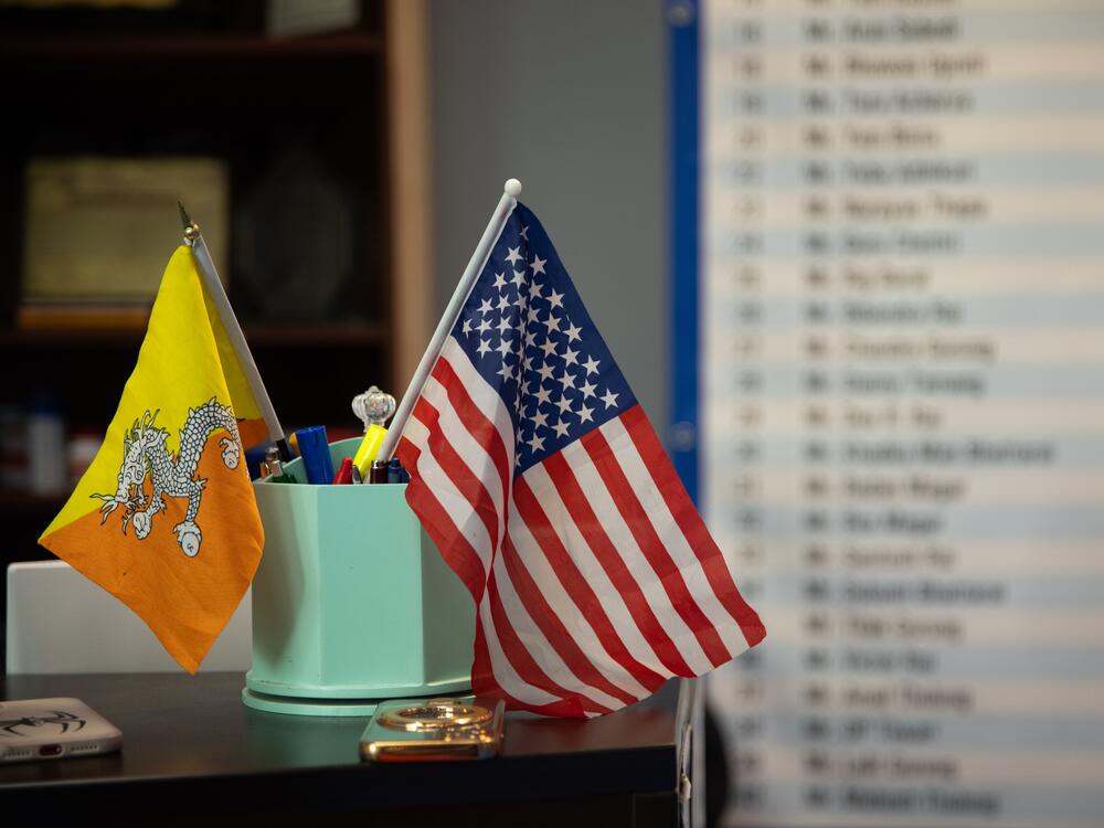 A Bhutanese and American flag are displayed on the desk of a business in Harrisburg, PA on April 16. This is not the first time that Nepali-speaking Bhutanese refugees have faced questions about citizenship and belonging. Some 30 years ago, they were branded as illegal immigrants by the Bhutanese government and were expelled or forced to flee.