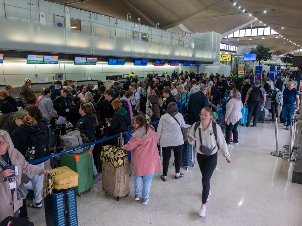 People wait in line at Newark Liberty International Airport in Newark, N.J. Air traffic control outages, runway construction and staffing shortages contributed to hundreds of delays and cancellations.
