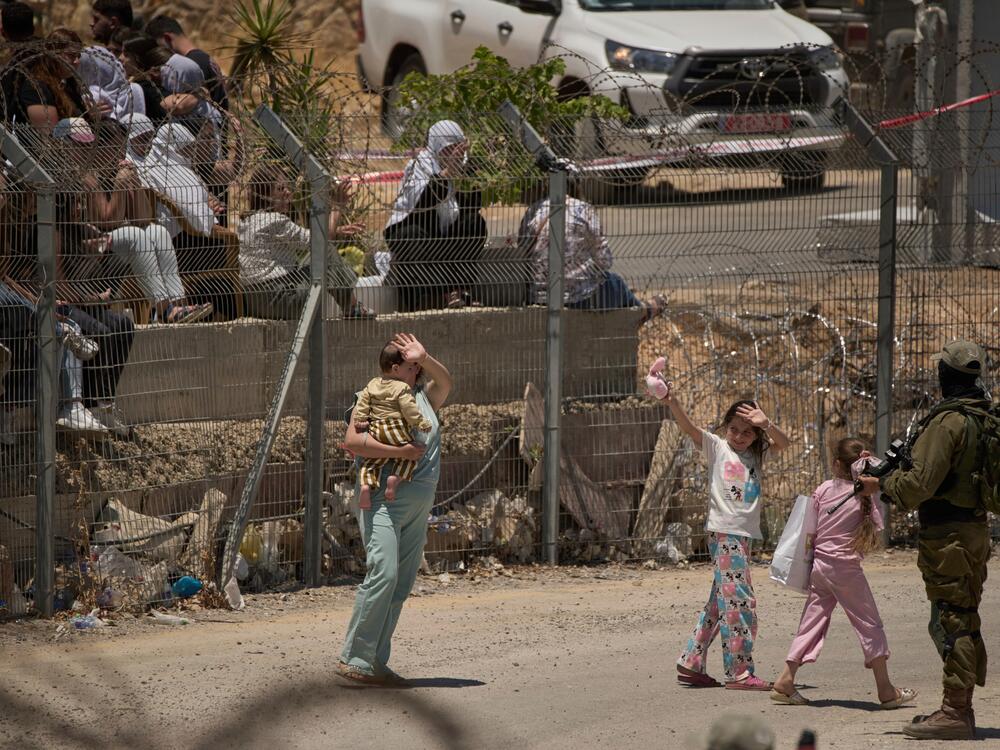 Members of a Syrian Druze family wave goodbye as they cross back into Syria at the Israeli-Syrian border, in the Israeli-controlled Golan Heights town of Majdal Shams, on Thursday.