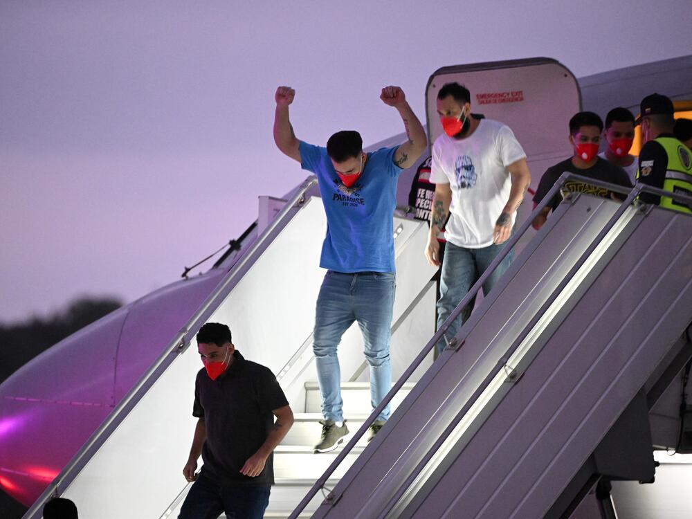 A Venezuelan migrant who was jailed in El Salvador gestures as he gets off a plane at Simon Bolívar International Airport in Maiquetía, Venezuela on Friday. El Salvador freed scores of Venezuelans deported from the United States to a notorious maximum security prison, the outcome of a highly coordinated prisoner swap between Caracas and Washington.