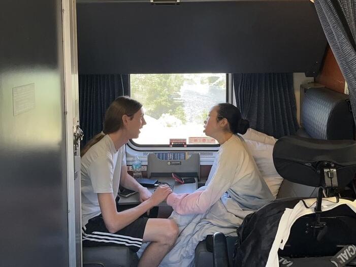 Peter Saathoff-Harshfield and Aubrie Lee hold hands while in their accessible room on the California Zephyr Amtrak train.