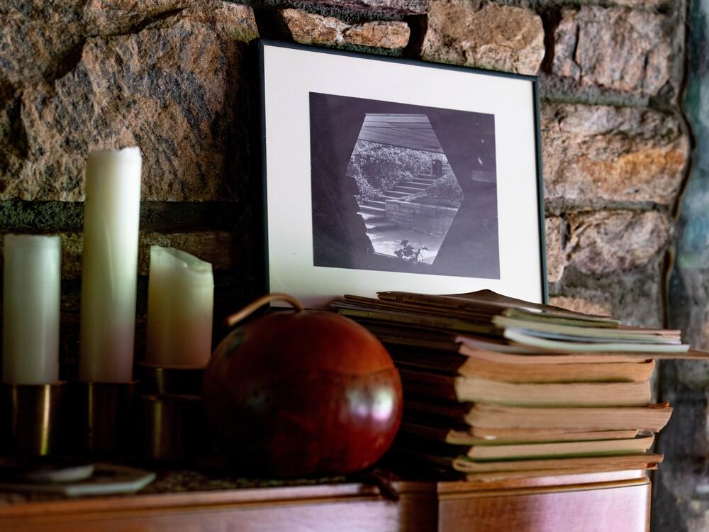 A framed photo of the home's hexagonal window hangs on the wall.