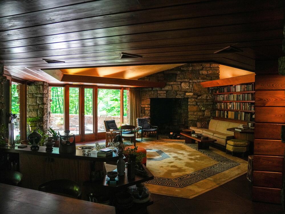 The great room features floor to ceiling glass doors that look out onto a canopy of maple and oak trees.