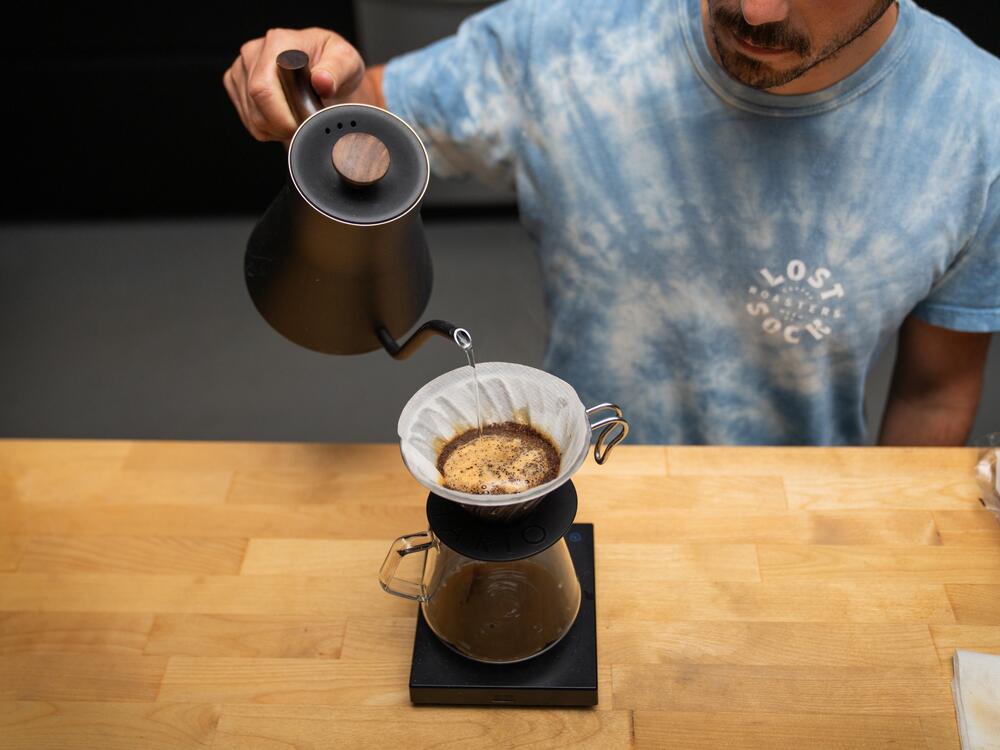 Yerxa brews a cup of coffee with freshly roasted beans at Lost Sock's roastery.