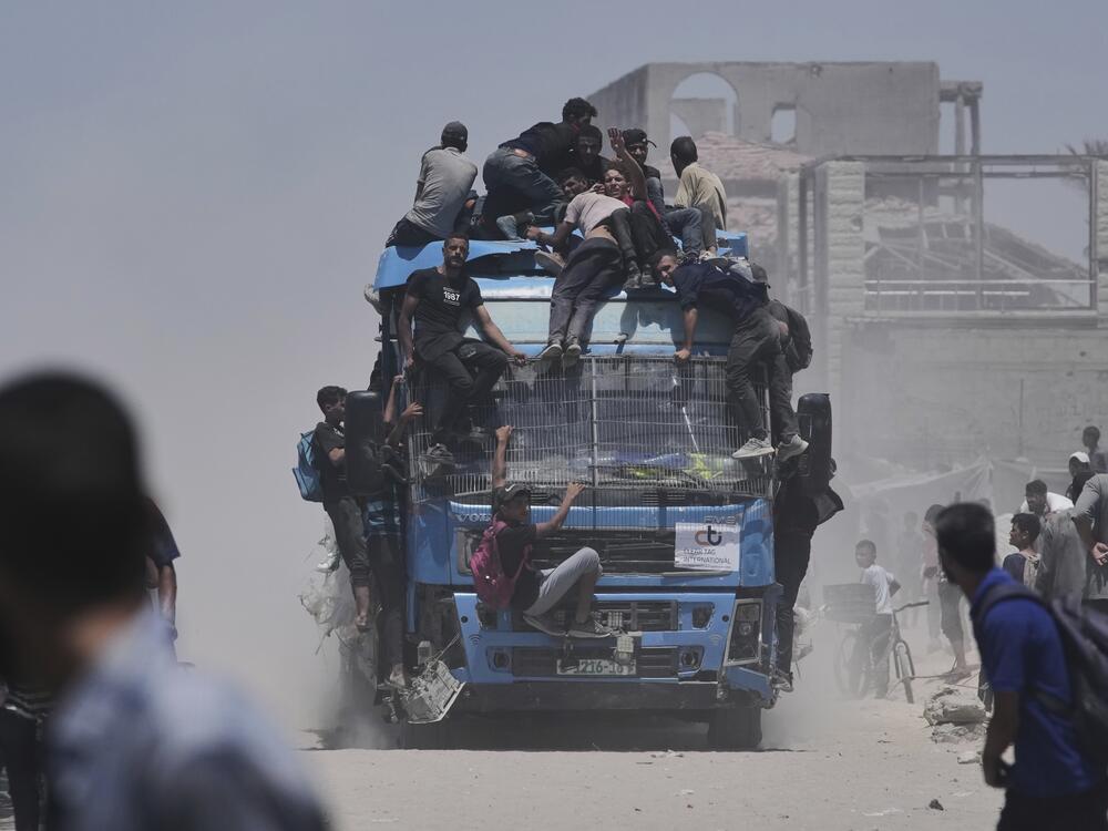 Palestinians hold onto an aid truck returning to Gaza City from the northern Gaza Strip on Tuesday.