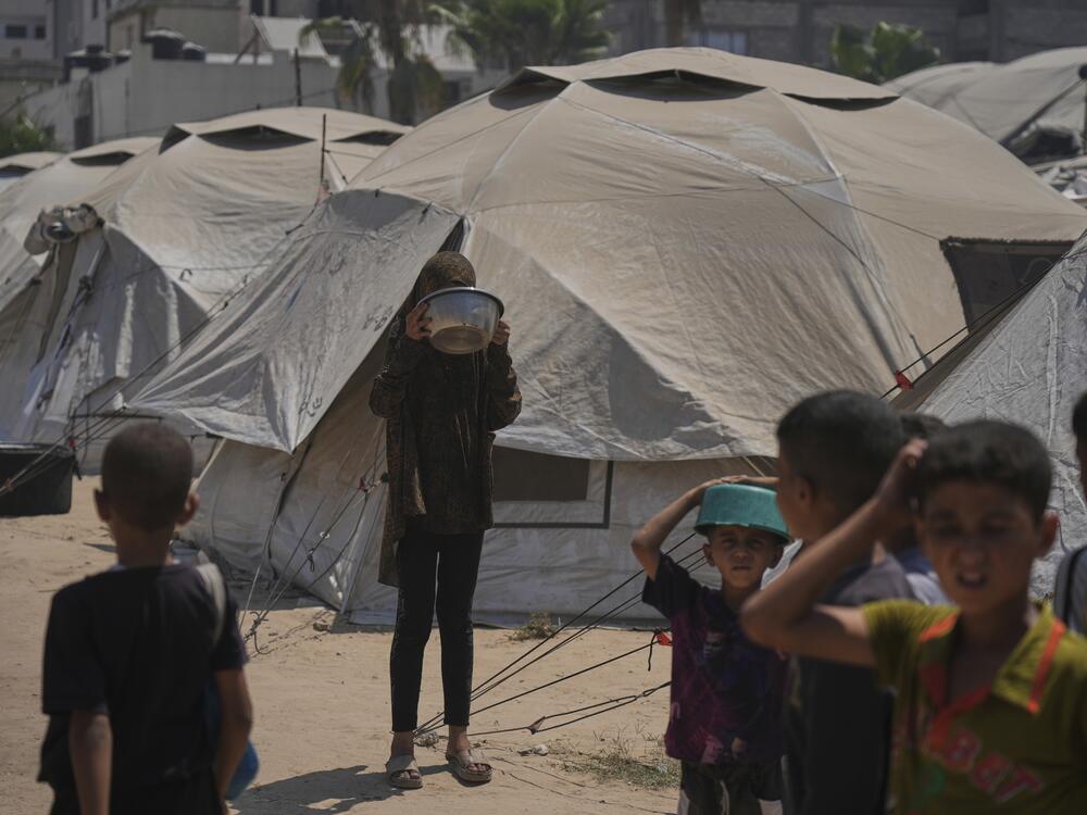 Displaced Palestinians wait for donated food at a community kitchen in Gaza City, northern Gaza Strip, Tuesday.