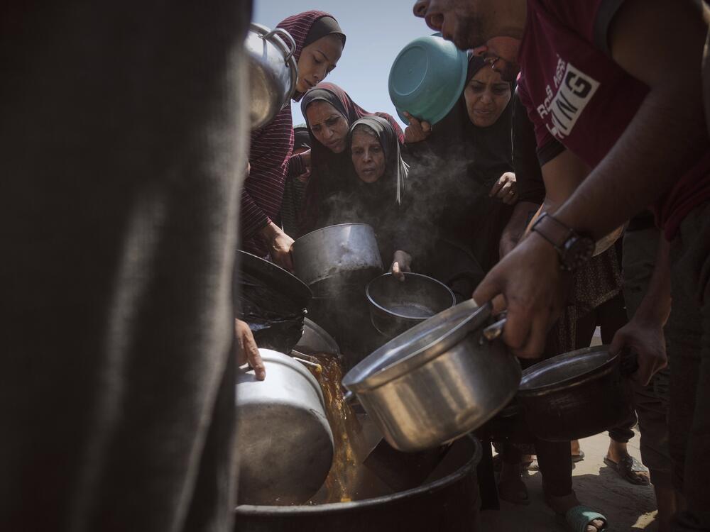 Displaced Palestinians receive donated food at a community kitchen in Gaza City, northern Gaza Strip on Tuesday.