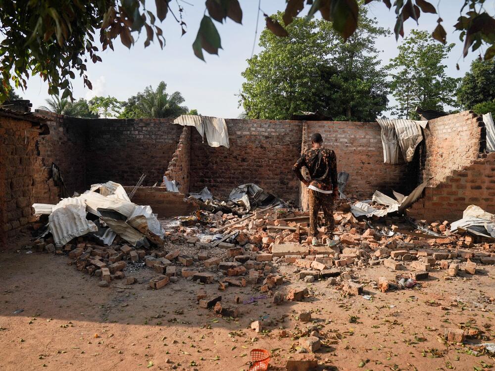 A man stands in front of a damaged and burnt house following a deadly gunmen attack in Yelwata, Benue State, Nigeria, on June 16, 2025.